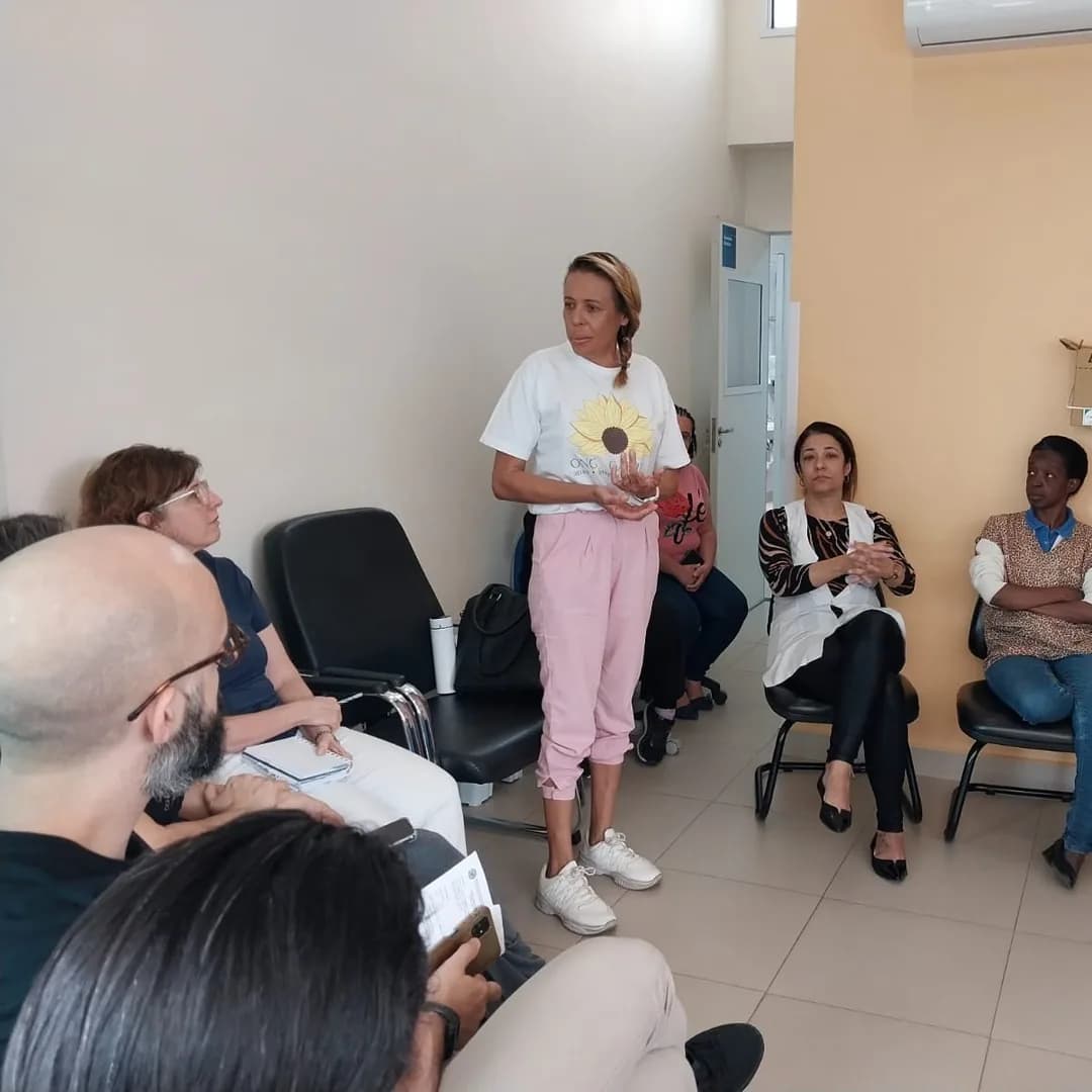 Roda de conversa da ONG Gabriel: uma pessoa em pé fala para o grupo sentado em círculo.