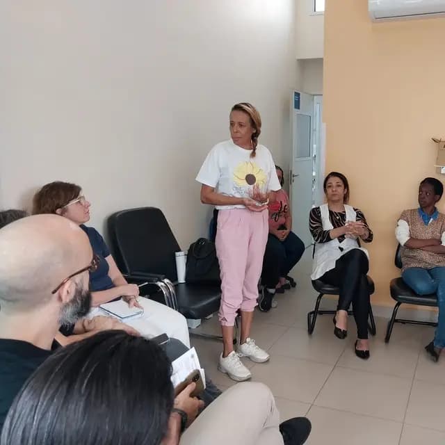 Voluntária da ONG Gabriel conversa com um grupo sentado em roda.